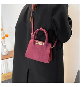 Detailed view of burgundy frosted suede mini handbag with gold square buckle and metal ring