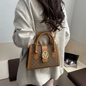 Brown crossbody bag with repeated M-pattern and golden logo buckle for daily use