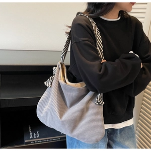 Détail du sac fourre-tout gris en velours côtelé avec bandoulière rayée et grande capacité