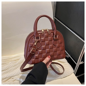 Macro shot of brown shell handbag featuring checkered embossed pattern and gold hardware