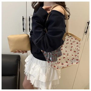 Detailed view of cherry print transparent PVC tote bag with leather inner pouch