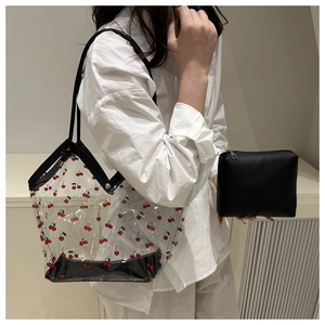 Detail of transparent PVC cherry print tote bag with a matching black inner pouch