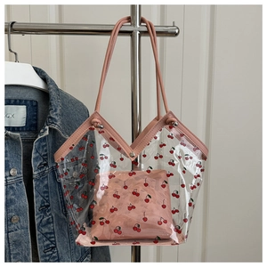 Detail of transparent PVC tote bag featuring cherry prints and pink inner pouch