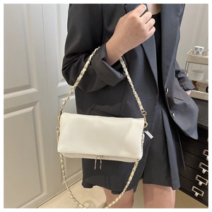 Detail of white litchi pattern shoulder bag with dual gold zippers and chain strap
