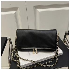 Detailed macro view of black litchi grain leather and golden double zipper accents