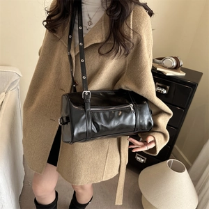 Sac Boston minimaliste en cuir noir avec bandoulière réglable dans un cadre de vie