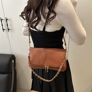 Brown pebbled leather shoulder bag with gold chain strap and decorative zipper detail