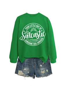 Dettaglio della felpa verde con grafica sole e pantaloncini in denim strappati set