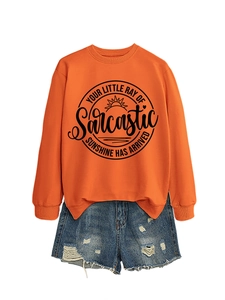 Dettaglio felpa arancione con stampa Sunshine e pantaloncini di jeans con strappi