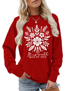 Detalle de una sudadera roja de cuello redondo con estampado floral blanco y frase inspiradora