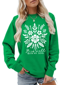 Detalle de sudadera verde de manga larga con estampado floral blanco y cita de alma