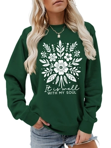 Detalle de sudadera verde oscuro con estampado floral blanco y texto de cita de alma