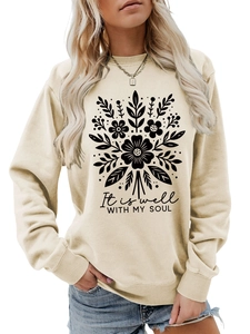 Detalle de sudadera beige claro con estampado floral y texto It is well WITH MY SOUL