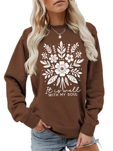 Detalle de estampado floral blanco y texto It is well WITH MY SOUL en sudadera marrón