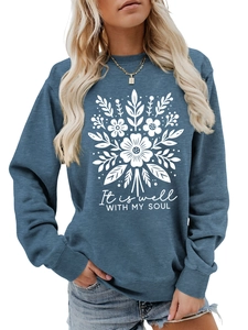 Detalle de sudadera azul con estampado floral blanco y texto It Is Well With My Soul