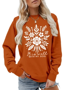 Detalle de la sudadera naranja caramelo con estampado floral blanco y texto It is well