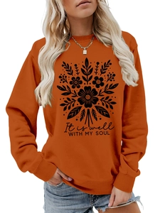 Detalle de sudadera naranja tostado con estampado floral y cita motivadora It is well