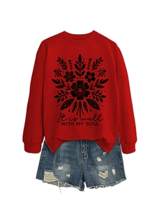 Primer plano de sudadera roja con estampado floral negro y texto motivacional