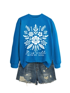 Detalle de sudadera azul real floral con texto y pantalones cortos de mezclilla con flecos