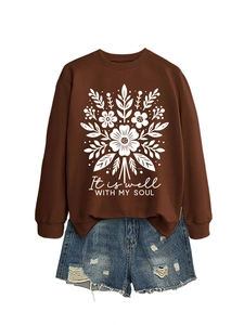 Detalle de sudadera marrón con flores It Is Well With My Soul y pantalones cortos denim