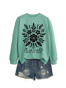 Detalle de sudadera verde menta con estampado floral y texto inspirador It is well with my soul