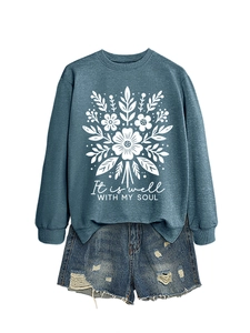 Detalle del estampado floral blanco y el texto 'It is well with my soul' en la sudadera gris