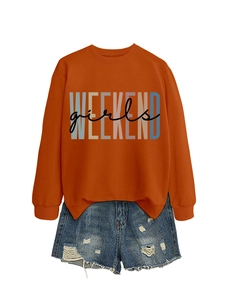 Detail of burnt orange sweatshirt with Weekend Girls print and distressed denim shorts