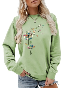 Detail of the crewneck sweatshirt featuring a colorful book dandelion print on mint green fabric
