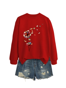 Flat lay of a red sweatshirt with dandelion book print and distressed blue denim shorts