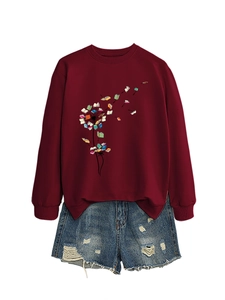 Detail of burgundy sweatshirt featuring a creative dandelion book print and ripped denim shorts