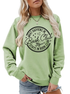 Close-up of sage green sweatshirt featuring What Happens in Book Club graphic print
