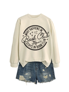 Flat lay of cream Book Club sweatshirt with vintage distressed denim shorts
