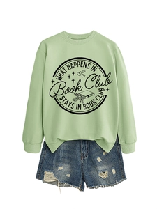 Detail of What Happens in Book Club print on mint green sweatshirt with denim shorts