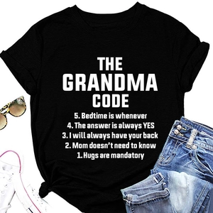 Flat lay of black crew neck T-shirt with white Grandma Code text and lifestyle accessories