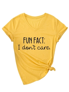 Dettaglio della maglietta gialla con scollo a V e lo slogan nero 'FUN FACT: I don't care.'