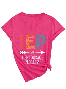 Detail of rose pink V-neck T-shirt featuring IEP slogan print and knot hem detail