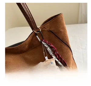 Gros plan d'un pendentif en peluche pain avec cordes sur un sac cabas marron