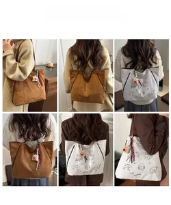 Vues détaillées d'un grand sac cabas en toile avec graffiti et pendentif en peluche