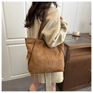 Sac fourre-tout marron en similicuir suédé avec illustrations graffiti sur le mannequin