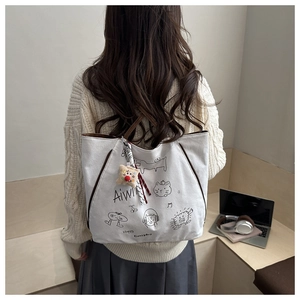 Detailed back view of a white canvas tote bag with brown leather straps and a cat print