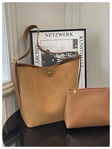Detail of camel suede tote bag with golden twist lock and matching leather inner pouch