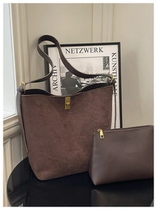 Detail of dark brown suede bucket bag with gold lock and matching leather pouch