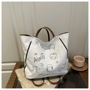 Detail der weißen Canvas-Tasche mit Katzen-Graffiti und braunen Ledergriffen
