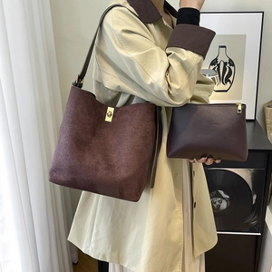 Retro brown suede tote bag with metal twist lock and matching pouch on a model
