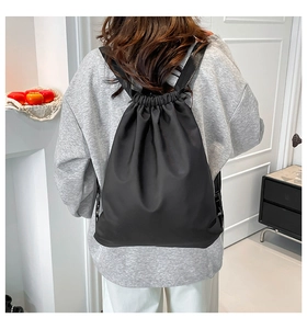 Detail of a black nylon drawstring backpack showing waterproof fabric and adjustable straps