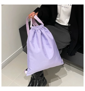 Close-up of lavender drawstring bucket bag showing lightweight glossy nylon texture