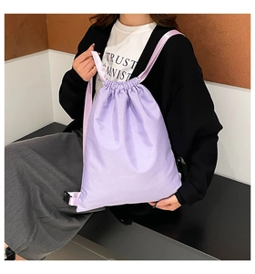 Detailed view of lavender drawstring backpack featuring purple woven straps and sturdy buckle