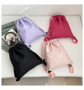 Flat lay view of four colorful lightweight nylon bucket backpacks with drawstring closure