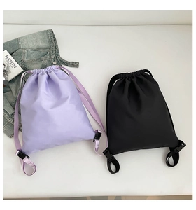 Detail view of lightweight nylon drawstring backpacks in lavender and black for travel