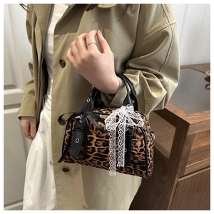 Dettaglio borsa leopardata con fiocco di pizzo bianco e fibbia in argento lucido